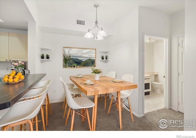 dining room with light carpet and an inviting chandelier