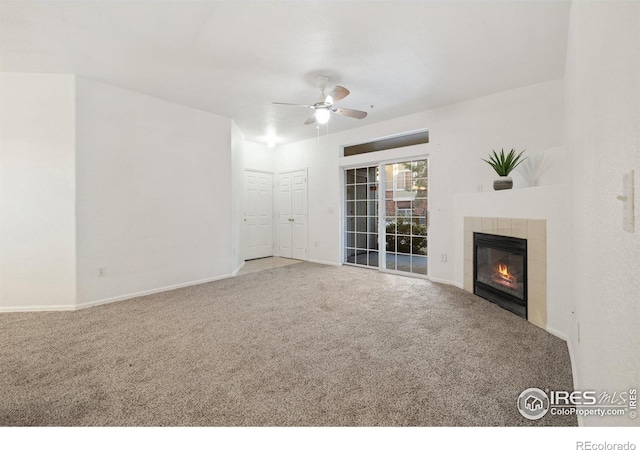 unfurnished living room featuring carpet, ceiling fan, and a tiled fireplace