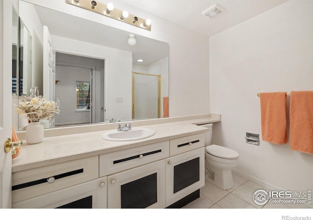 bathroom featuring a shower with shower door, tile patterned floors, vanity, and toilet