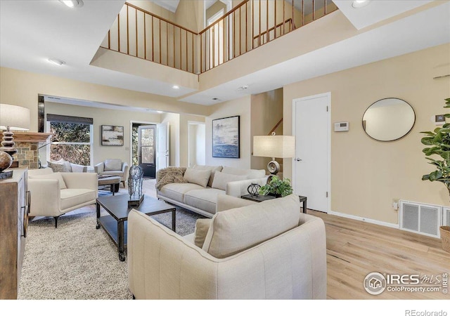 living room featuring light hardwood / wood-style floors and a towering ceiling