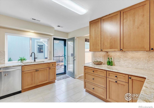 kitchen featuring decorative backsplash, dishwasher, light stone counters, and sink