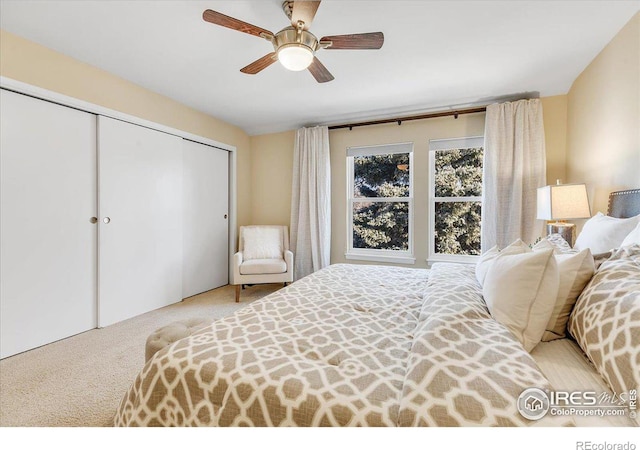 carpeted bedroom with ceiling fan and a closet