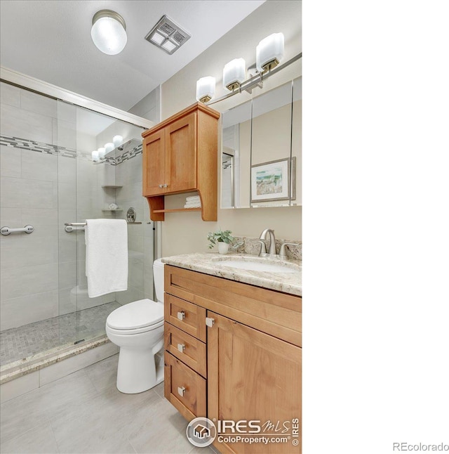 bathroom with toilet, a shower with door, and vanity