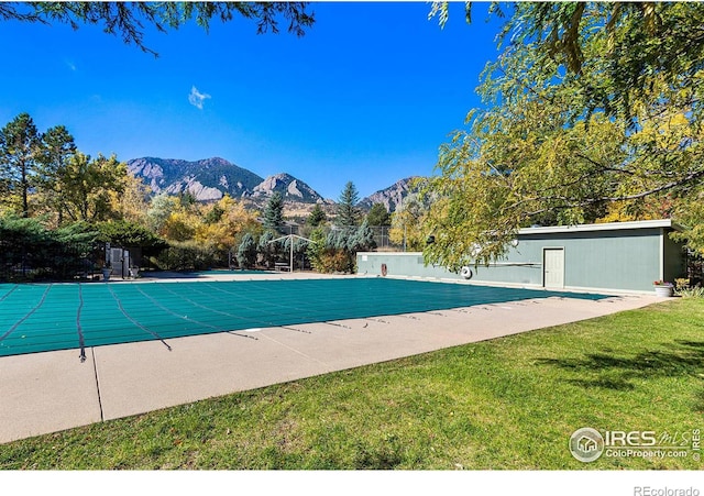 view of swimming pool featuring a lawn, a patio area, and a mountain view