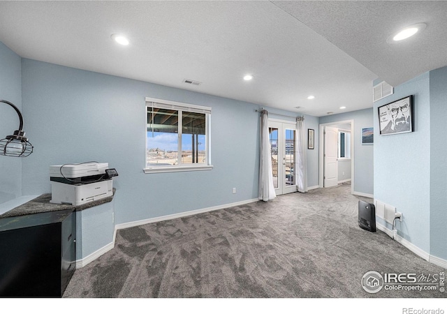 interior space featuring carpet, french doors, and a textured ceiling