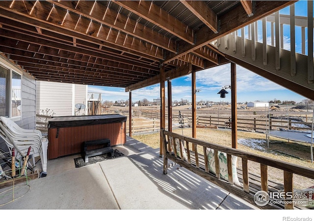 view of patio / terrace featuring a hot tub and a rural view