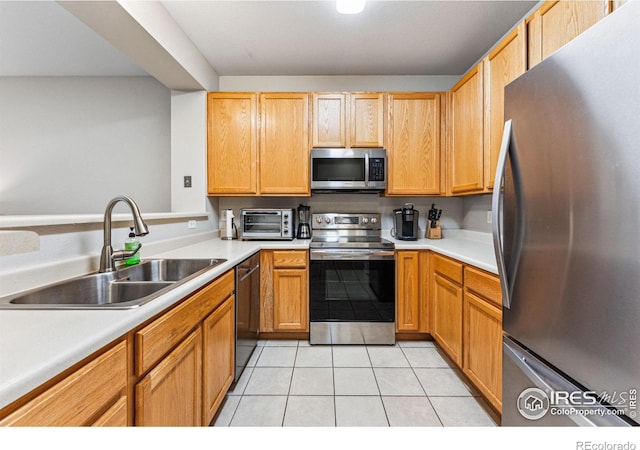 kitchen featuring light tile patterned flooring, appliances with stainless steel finishes, and sink