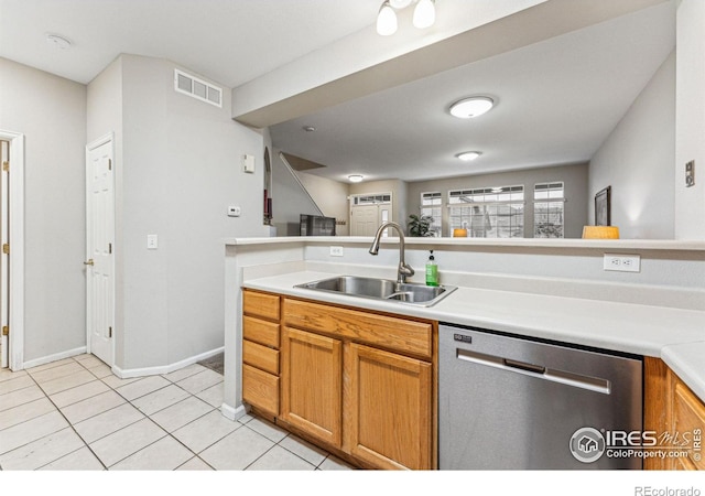 kitchen featuring sink, dishwasher, and light tile patterned flooring