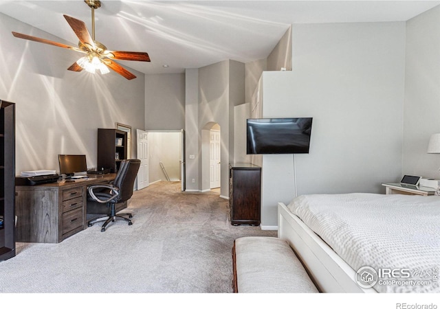 carpeted bedroom with ceiling fan and high vaulted ceiling