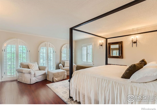 bedroom with ornamental molding, dark hardwood / wood-style floors, radiator heating unit, and a textured ceiling