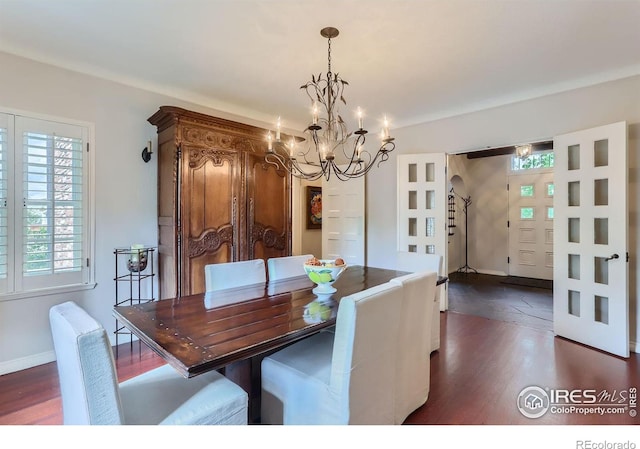 dining space with dark hardwood / wood-style floors and a notable chandelier