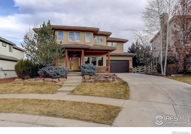 prairie-style house featuring a front lawn and a garage