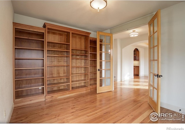 empty room with hardwood / wood-style floors and french doors