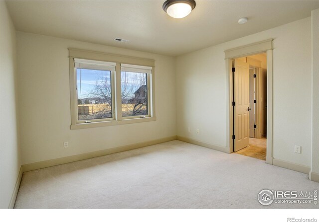 unfurnished room featuring light carpet