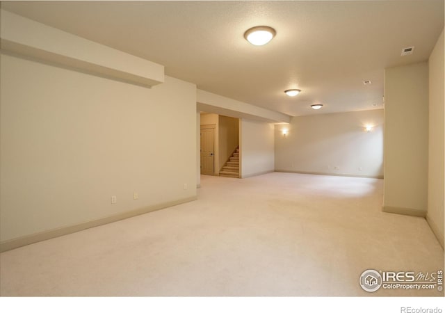 basement with a textured ceiling and carpet flooring