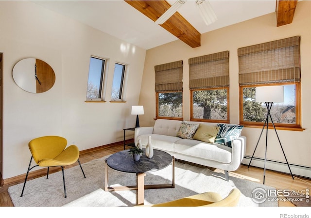 living room featuring light wood-type flooring, a wealth of natural light, a baseboard radiator, and beamed ceiling