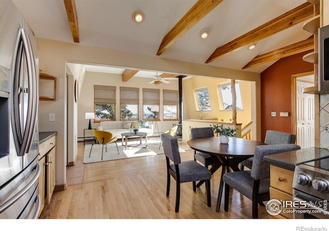 dining space featuring ceiling fan, light hardwood / wood-style floors, and lofted ceiling with beams