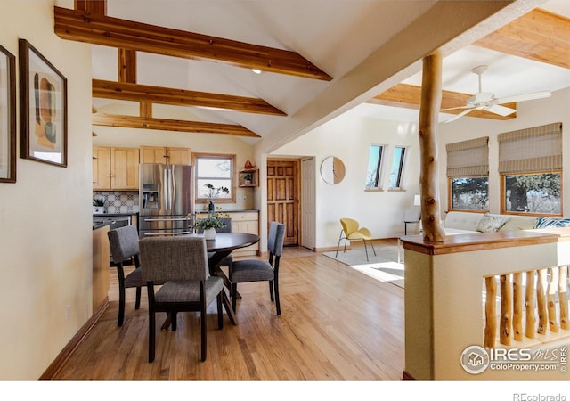 dining space featuring light wood-type flooring, ceiling fan, and vaulted ceiling with beams