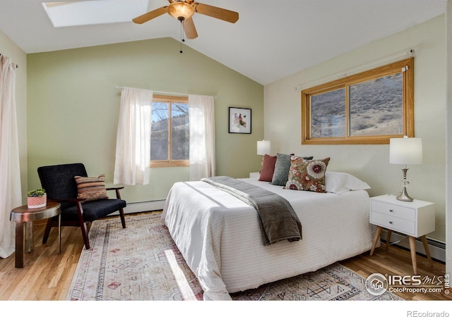 bedroom featuring ceiling fan, lofted ceiling, light hardwood / wood-style floors, and baseboard heating