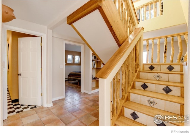 stairs with beamed ceiling