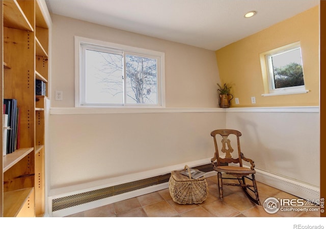 sitting room with baseboard heating and light tile patterned floors