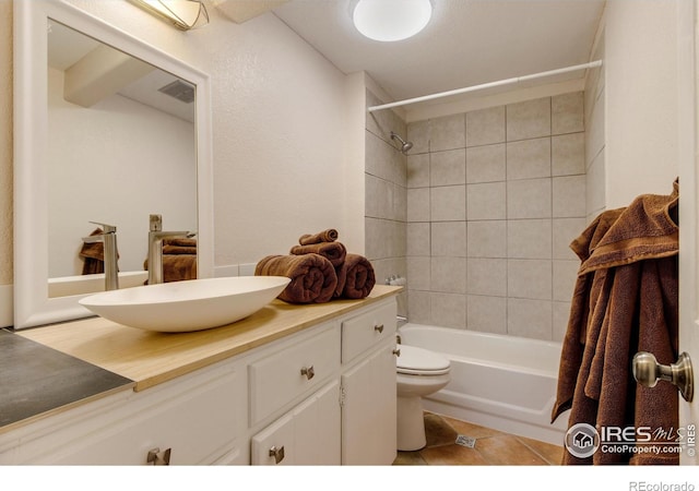 full bathroom featuring toilet, vanity, tile patterned floors, and tiled shower / bath