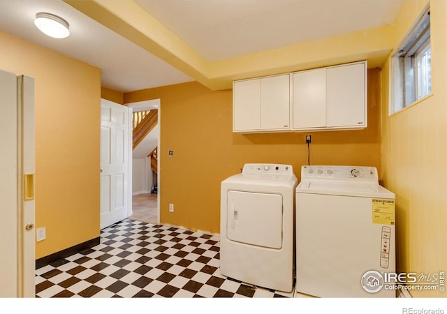 laundry area with separate washer and dryer and cabinets