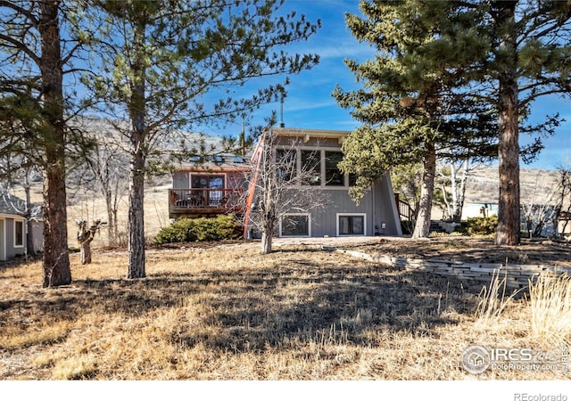 rear view of property featuring a wooden deck