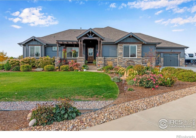 craftsman house with a garage and a front lawn