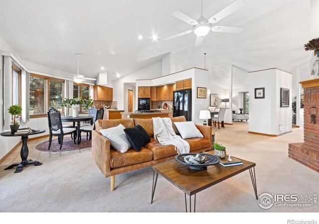 living room featuring ceiling fan, light colored carpet, vaulted ceiling, and a fireplace