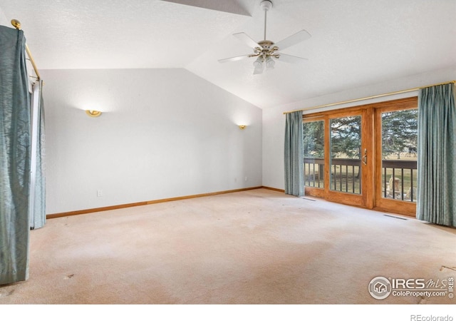 interior space with vaulted ceiling, ceiling fan, and light carpet