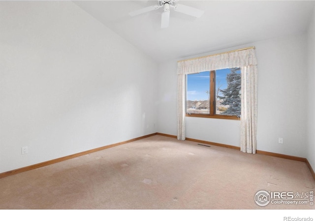 empty room with ceiling fan, lofted ceiling, and light carpet