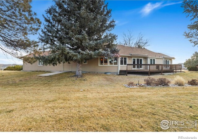 back of house with a lawn and a deck