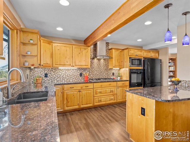 kitchen featuring hanging light fixtures, sink, wall chimney range hood, dark stone countertops, and black appliances