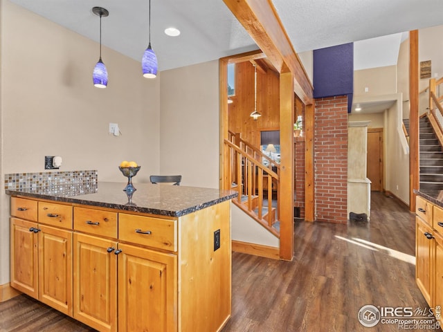 kitchen with hanging light fixtures, decorative backsplash, dark stone countertops, kitchen peninsula, and dark hardwood / wood-style flooring