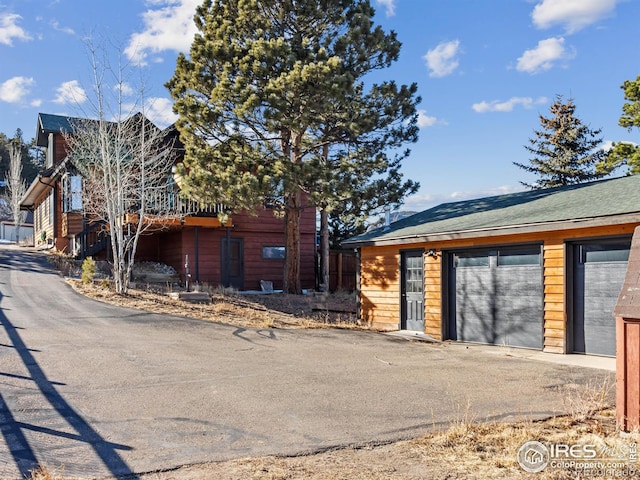 view of front of home featuring a garage and an outbuilding