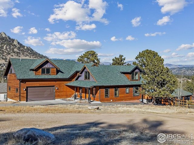 log home with a garage and a mountain view