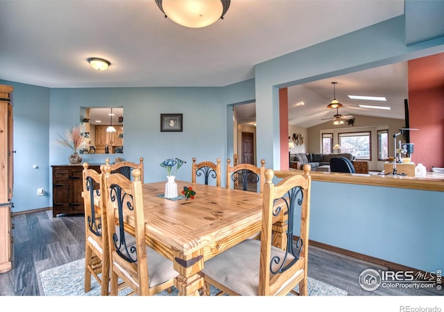 dining area featuring dark hardwood / wood-style flooring, vaulted ceiling, and ceiling fan