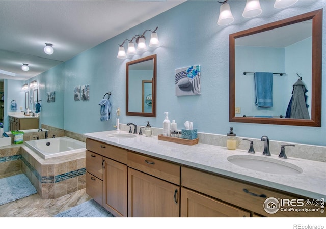 bathroom featuring vanity and tiled bath