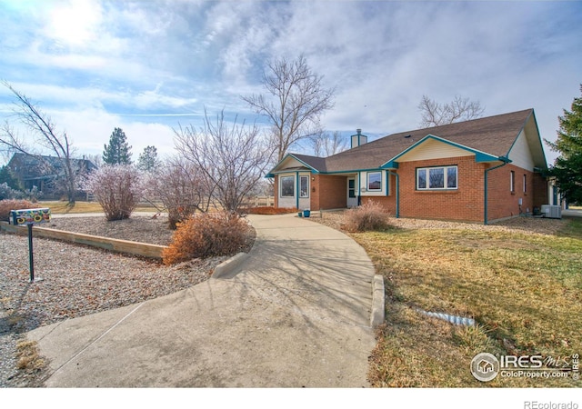 single story home featuring cooling unit and a front lawn