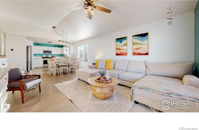 living room with vaulted ceiling, ceiling fan, and light hardwood / wood-style floors