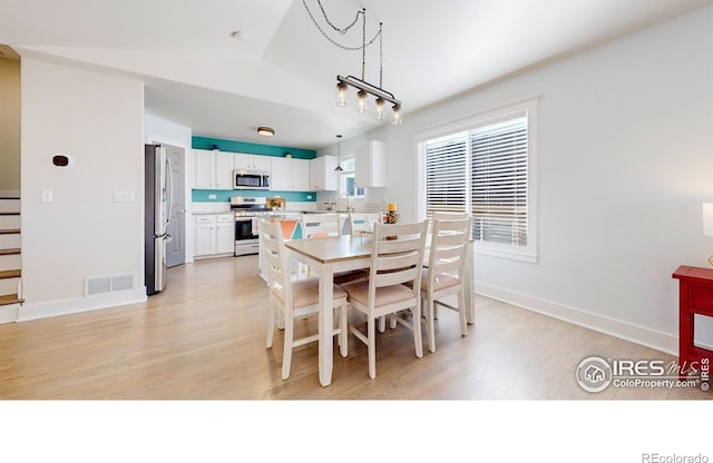 dining room with an inviting chandelier and light hardwood / wood-style flooring