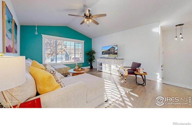 living room with ceiling fan, hardwood / wood-style flooring, and lofted ceiling