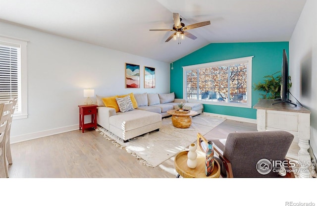 living room featuring ceiling fan, lofted ceiling, and light hardwood / wood-style floors