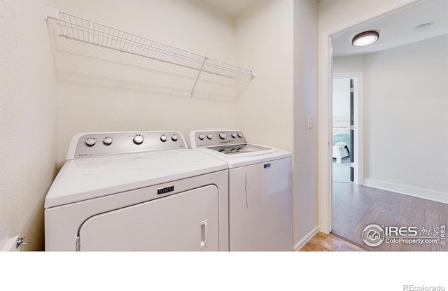 laundry room with washer and dryer and light hardwood / wood-style floors