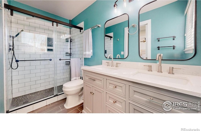 bathroom with toilet, baseboard heating, an enclosed shower, and vanity