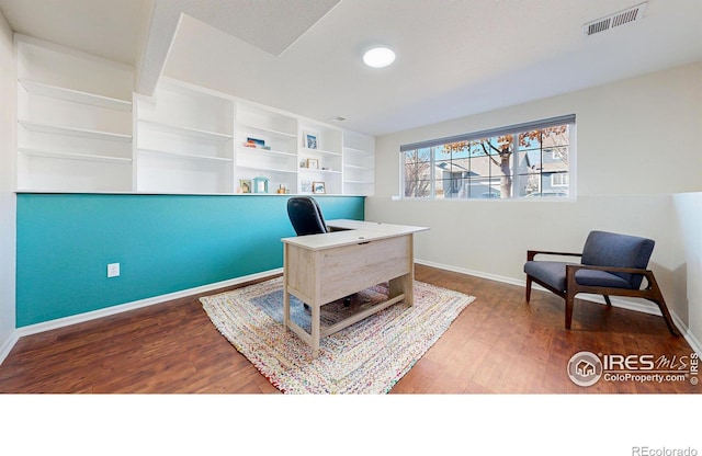 office featuring hardwood / wood-style floors and built in shelves