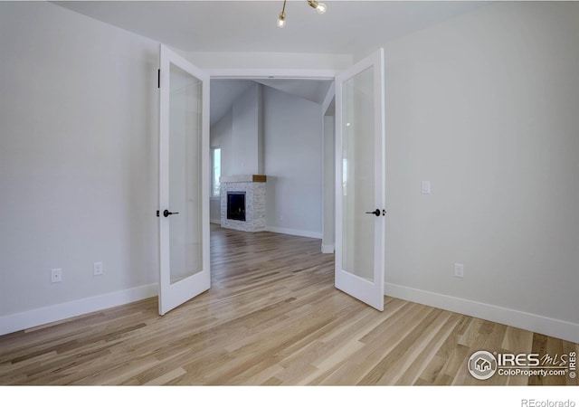 empty room featuring a fireplace and light hardwood / wood-style flooring