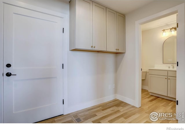 laundry room with sink and light wood-type flooring