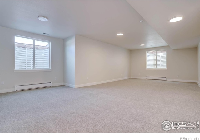 bonus room with light colored carpet and baseboard heating